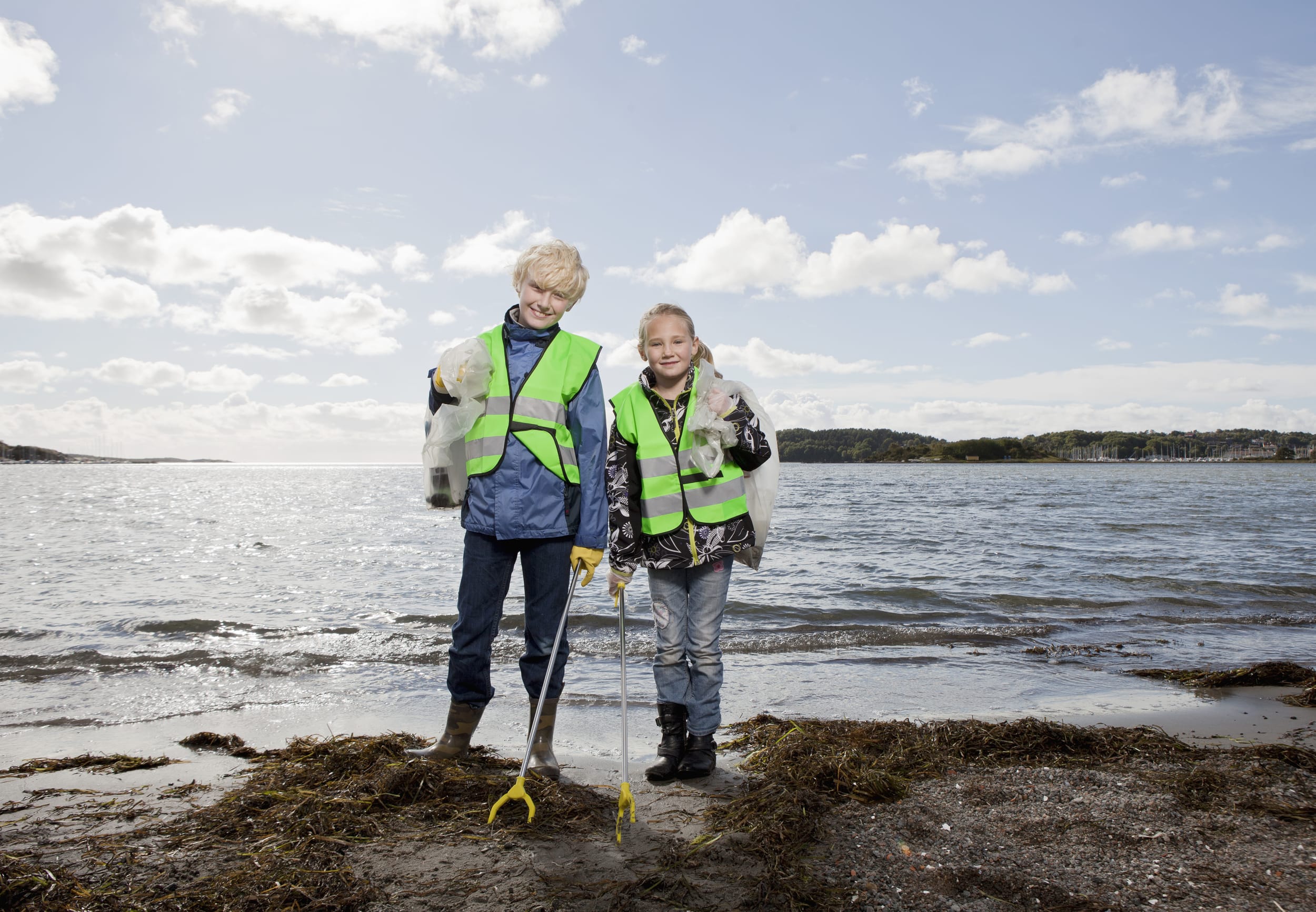 Barn som leker ved kysten i redningsvest